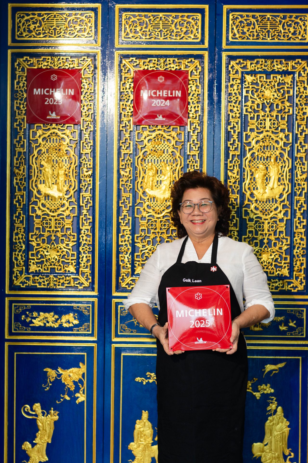 Auntie Gaik Lean holding her Michelin Guide plaque