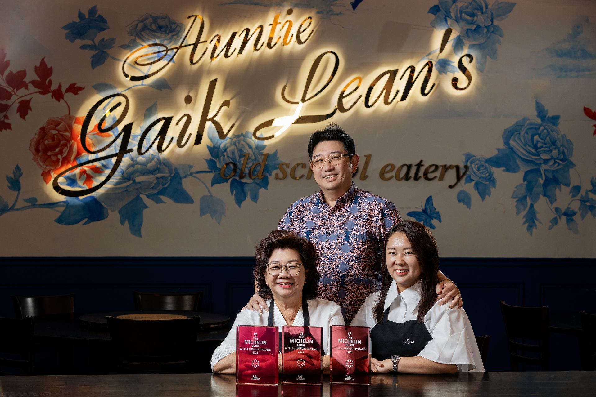 Auntie Gaik Lean with son Adrian Tan and daughter-in-law Jayna Tang holding three Michelin plaques